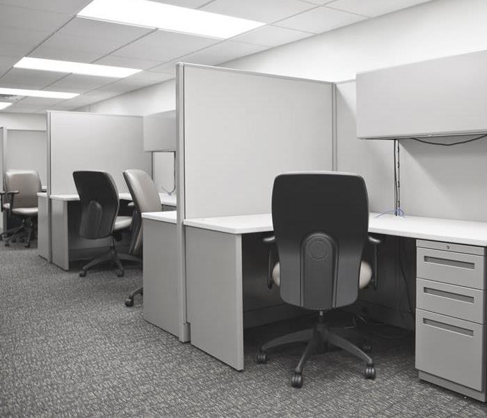 A row of empty office cubicles in a new grey office space