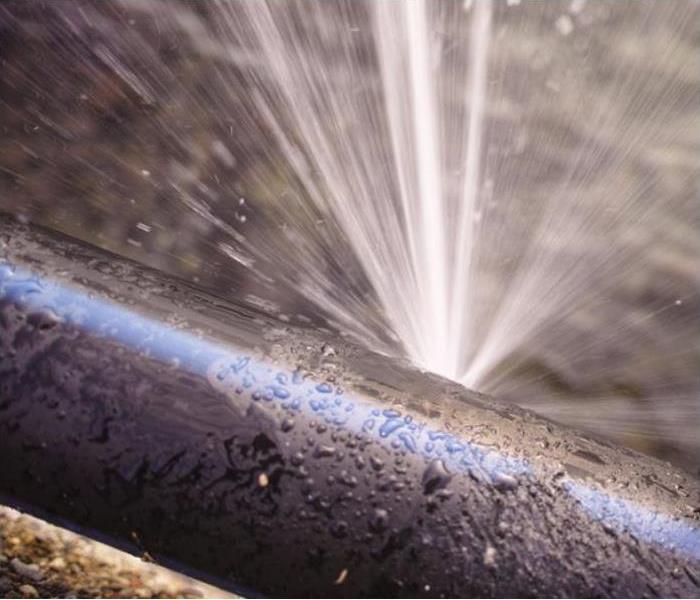 A close-up shot of a burst plumbing pipe