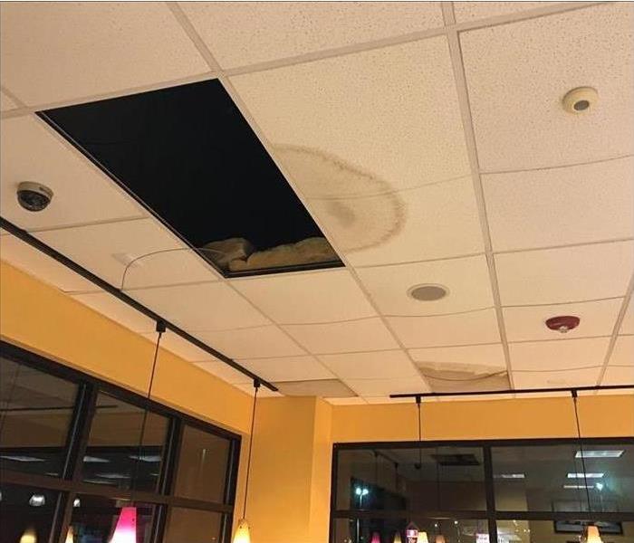commercial building interior with square ceiling tile missing and water damage present elsewhere